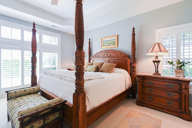 carpeted bedroom featuring multiple windows and ceiling fan