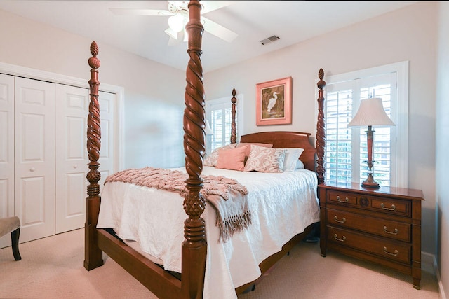 carpeted bedroom with ceiling fan and a closet