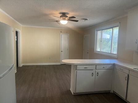 kitchen featuring white cabinetry, white fridge, dark hardwood / wood-style floors, kitchen peninsula, and ceiling fan