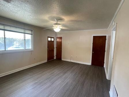 unfurnished room featuring ceiling fan, a textured ceiling, dark hardwood / wood-style floors, and ornamental molding