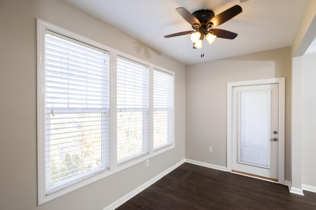 empty room with ceiling fan and dark wood-type flooring