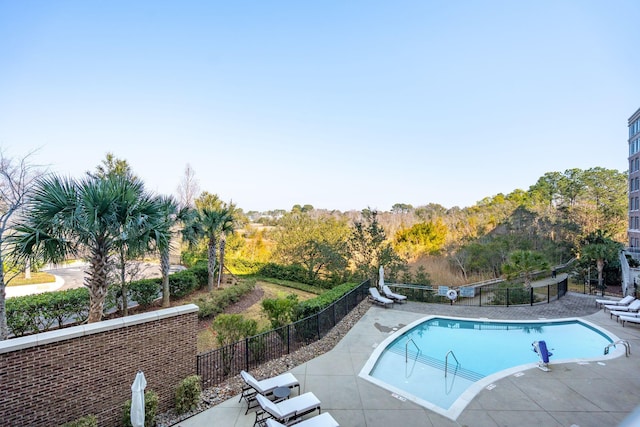 pool with a patio and fence