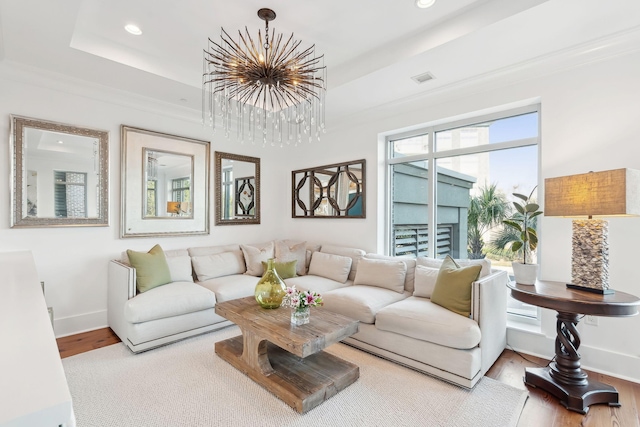 living room featuring a raised ceiling, baseboards, and wood finished floors