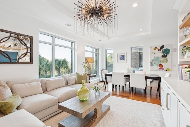 sunroom featuring a raised ceiling, visible vents, and a notable chandelier