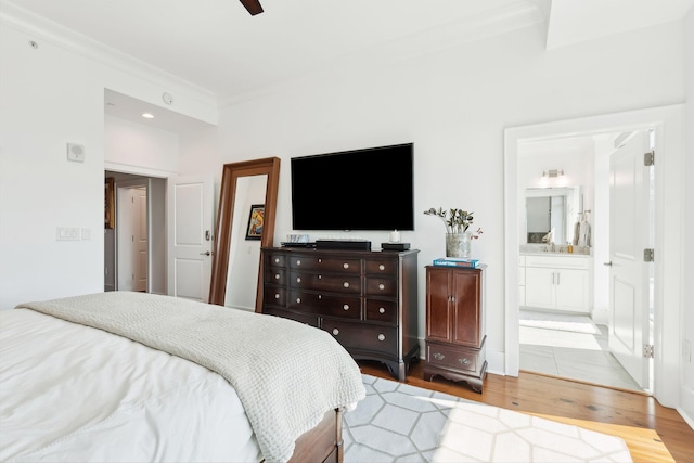 bedroom with ensuite bathroom, ceiling fan, ornamental molding, and wood finished floors