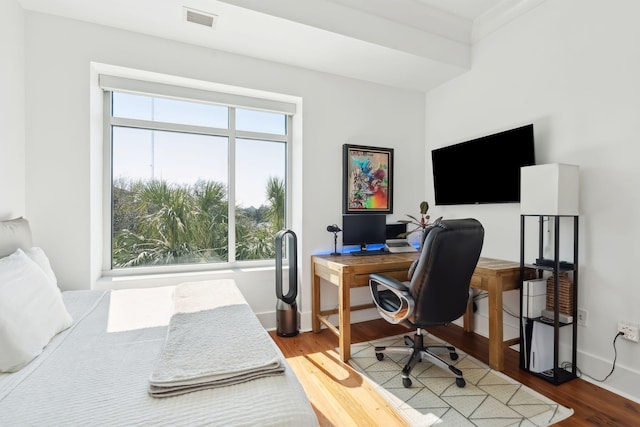 bedroom featuring wood finished floors, visible vents, baseboards, and multiple windows