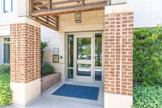 entrance to property featuring brick siding