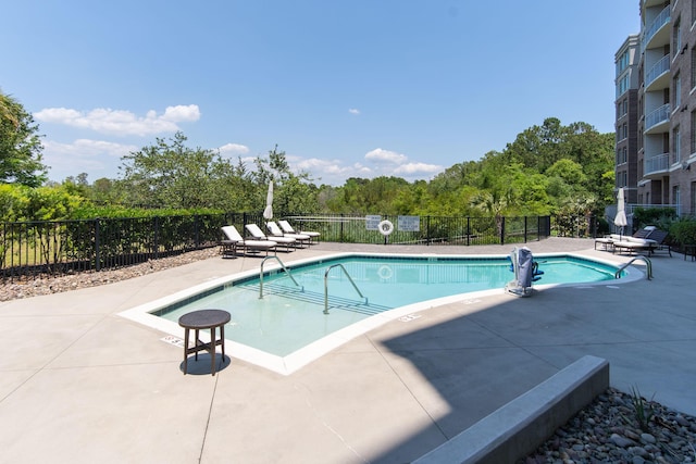 community pool featuring fence and a patio