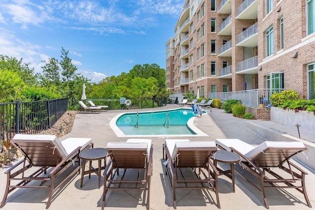 pool with fence and a patio