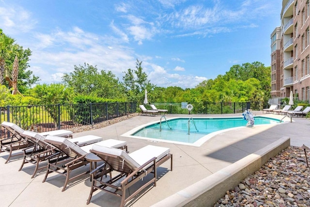 community pool featuring a patio and fence