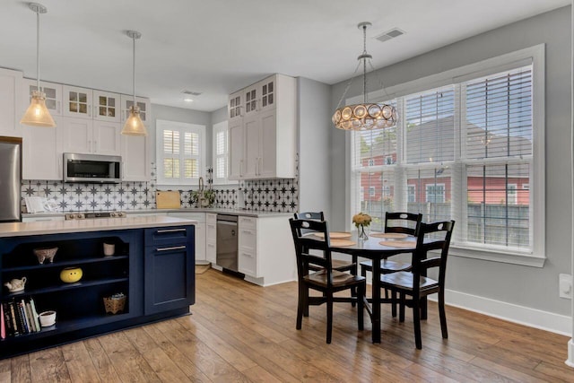 kitchen featuring light hardwood / wood-style floors, white cabinetry, stainless steel appliances, and tasteful backsplash