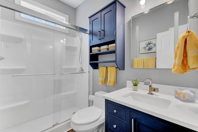 bathroom featuring vanity, toilet, and a shower with shower door