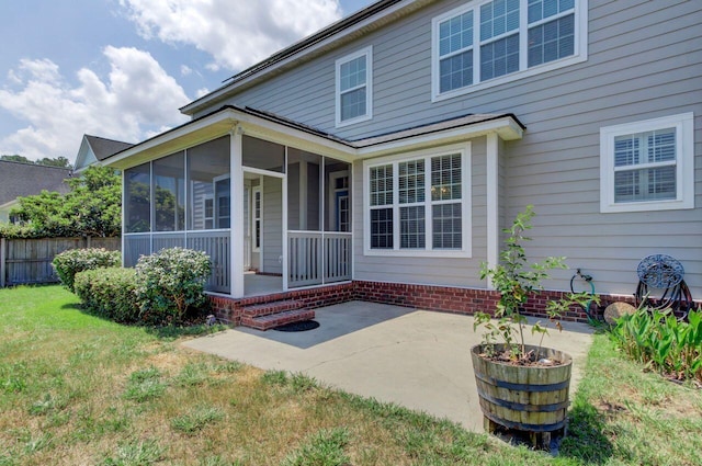 back of property with a yard, a patio area, and a sunroom