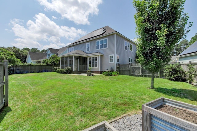 rear view of property featuring a sunroom and a yard