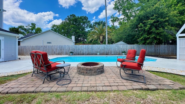 view of pool with a fire pit, a fenced backyard, and a patio area