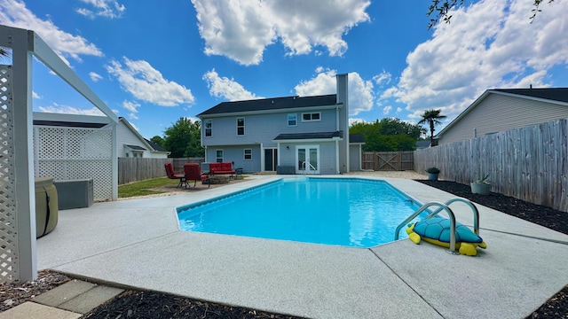 view of swimming pool with a patio, french doors, a fenced backyard, and an outdoor hangout area