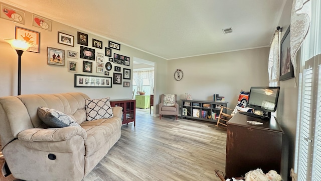 living room with light wood-style floors and ornamental molding