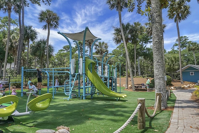 community jungle gym with fence and a yard