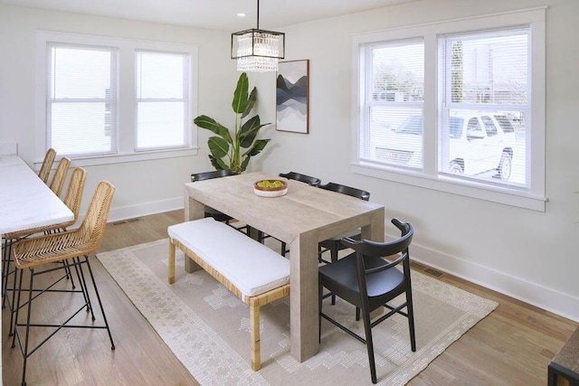 dining area with baseboards, a chandelier, and a wealth of natural light