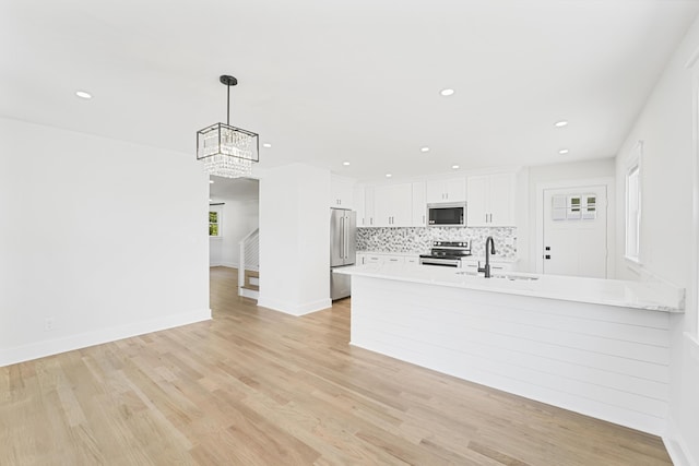kitchen featuring decorative backsplash, light countertops, white cabinetry, a sink, and stainless steel appliances