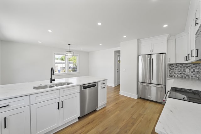 kitchen with light wood-type flooring, a sink, stainless steel appliances, recessed lighting, and white cabinetry