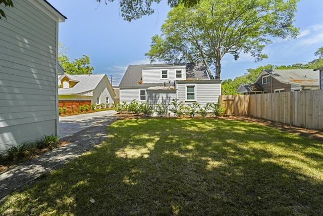 back of property featuring a yard and fence