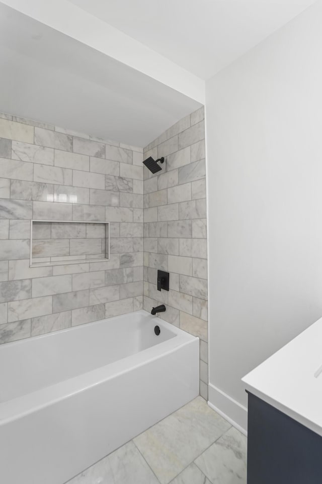 full bath featuring baseboards, washtub / shower combination, vanity, and marble finish floor