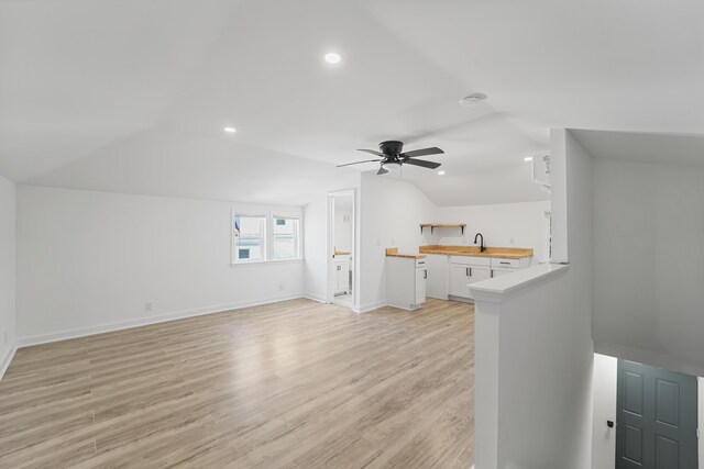 unfurnished living room with a ceiling fan, light wood-type flooring, a sink, lofted ceiling, and recessed lighting