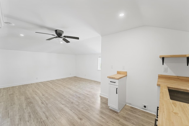 additional living space with lofted ceiling, baseboards, ceiling fan, light wood-type flooring, and recessed lighting