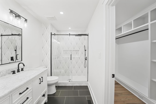 bathroom with visible vents, a stall shower, vanity, tile patterned floors, and toilet