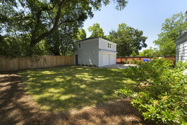 view of yard with an attached garage and fence