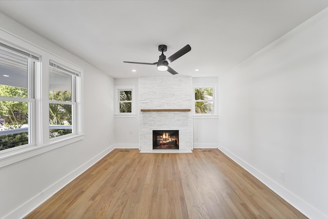 unfurnished living room with ceiling fan, a fireplace, baseboards, light wood finished floors, and recessed lighting