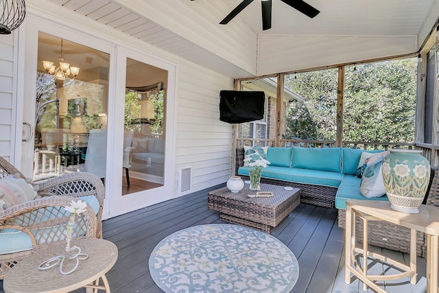 sunroom with vaulted ceiling, ceiling fan with notable chandelier, and a wealth of natural light