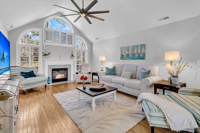 living room featuring high vaulted ceiling, ceiling fan, and light hardwood / wood-style flooring