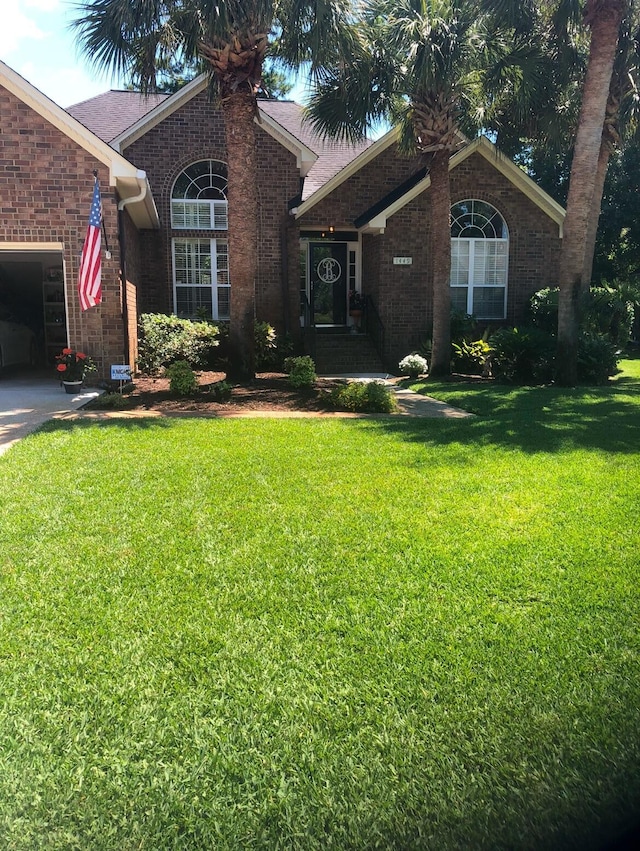 ranch-style home with a garage and a front lawn