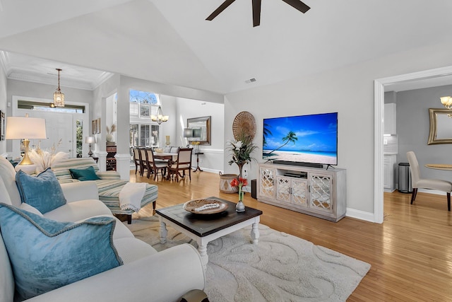 living room with ceiling fan with notable chandelier, lofted ceiling, and light hardwood / wood-style floors