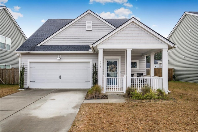 view of front of property with a porch, a garage, and a front yard