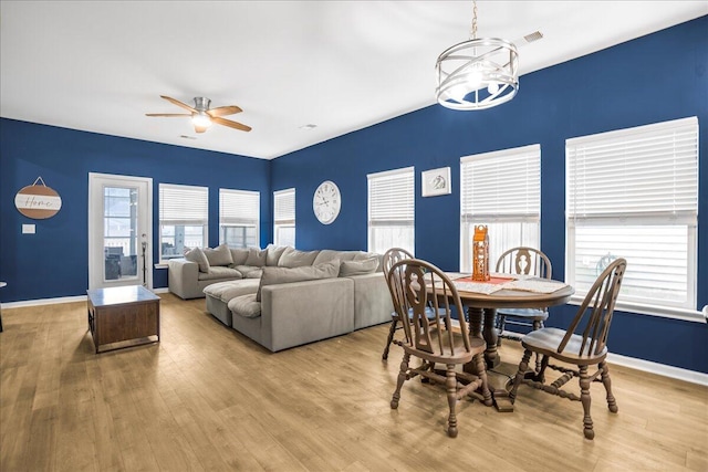 dining area featuring ceiling fan with notable chandelier and light hardwood / wood-style floors