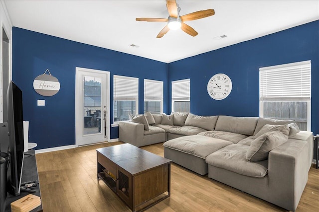 living room with ceiling fan and light hardwood / wood-style flooring