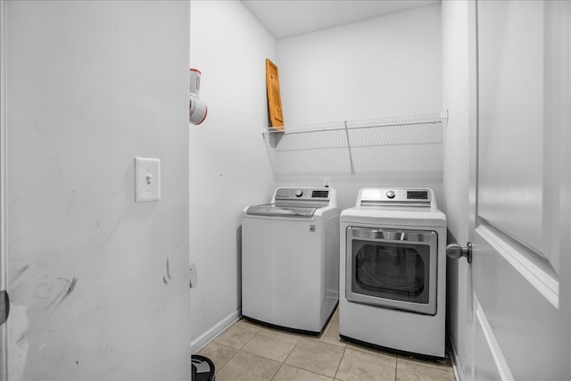 laundry room with light tile patterned floors and washing machine and clothes dryer