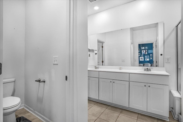 bathroom with tile patterned flooring, vanity, and toilet