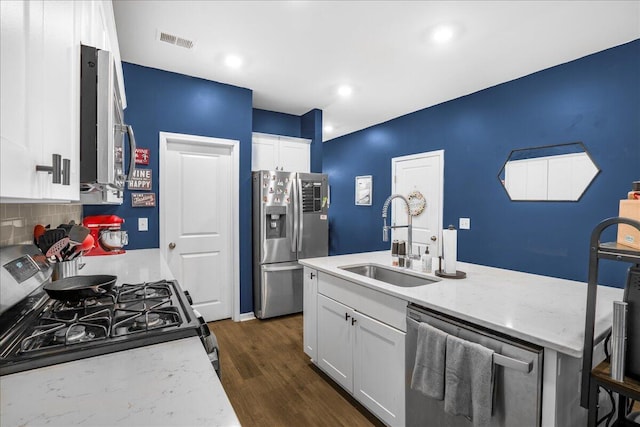 kitchen featuring backsplash, stainless steel appliances, sink, white cabinets, and dark hardwood / wood-style floors