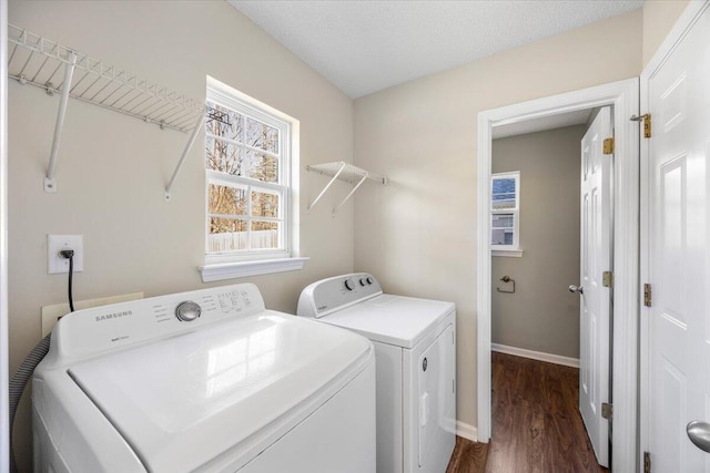 washroom featuring a textured ceiling, washer and clothes dryer, and dark hardwood / wood-style floors