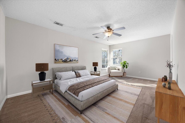 bedroom with ceiling fan, a textured ceiling, and carpet floors