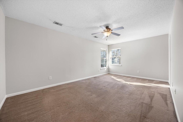 carpeted spare room with ceiling fan and a textured ceiling