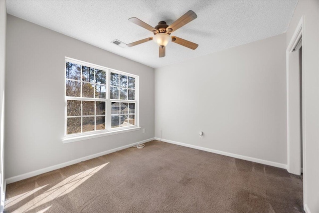 carpeted empty room featuring a textured ceiling and ceiling fan