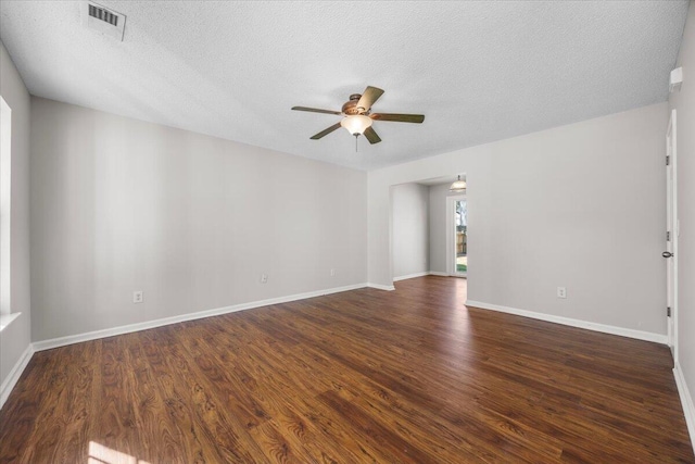 empty room with ceiling fan, dark hardwood / wood-style floors, and a textured ceiling