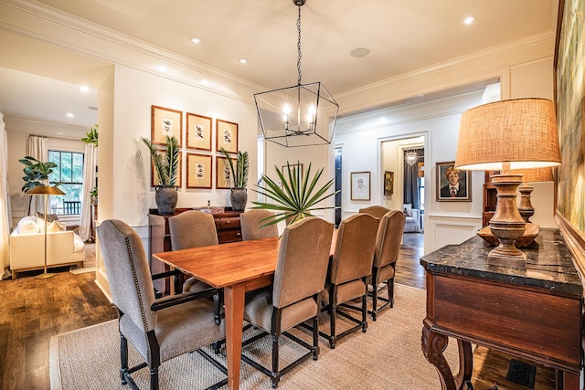 dining area featuring an inviting chandelier, crown molding, and light hardwood / wood-style flooring