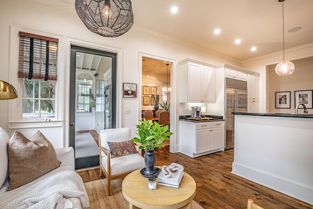 living room featuring crown molding, dark hardwood / wood-style flooring, and sink