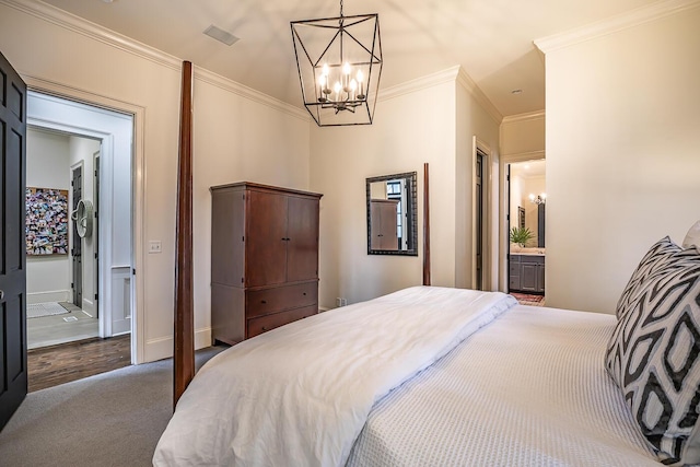 bedroom with carpet floors, an inviting chandelier, ensuite bath, and ornamental molding